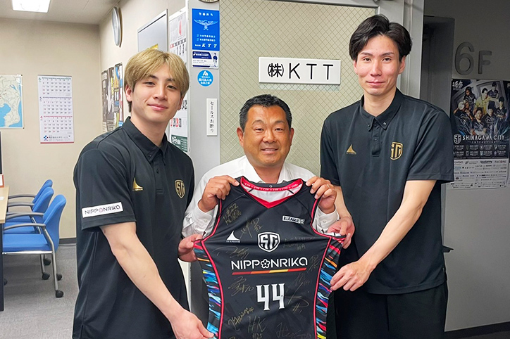SHINAGAWA CITY BASKETBALL CLUBの選手が会社訪問。選手に挟まれてユニフォームをもつ橋本代表